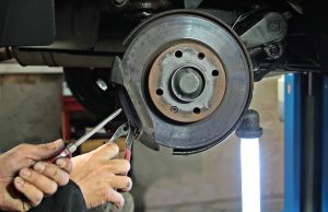 man working on brake disc in auto repair shop