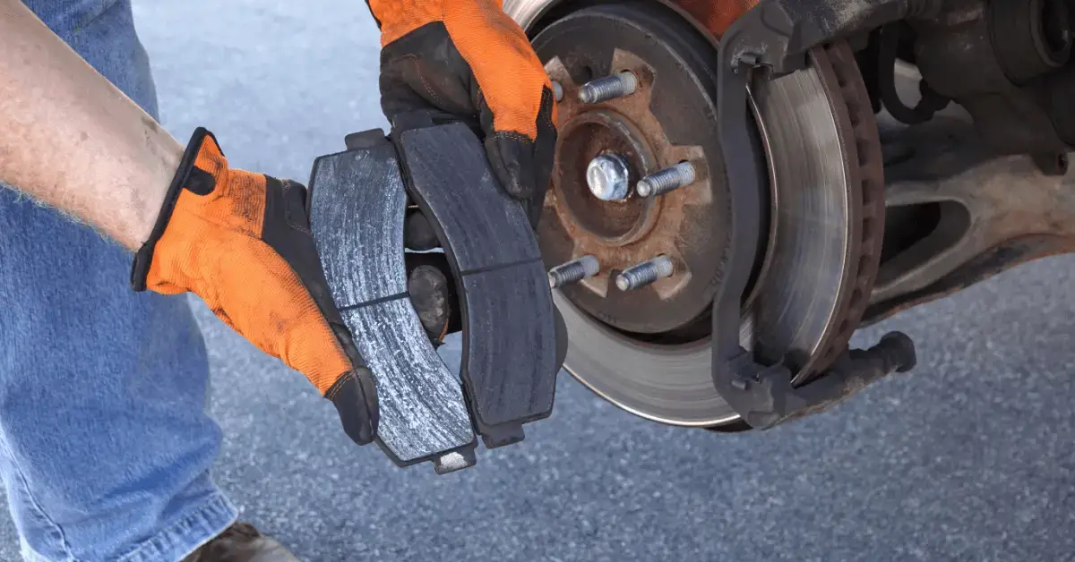 mechanic holding used brake pads